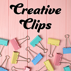 colored binder clips on pink background