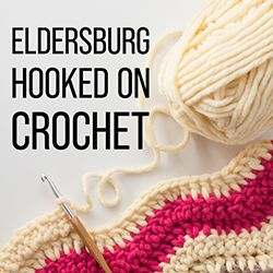 crochet hook and cream and magenta yarn