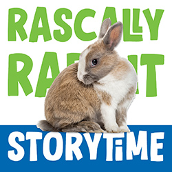 A brown and white bunny sitting on a blue box with storytime written in white