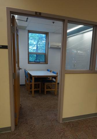 Entrance into a small study room with four chairs and a table