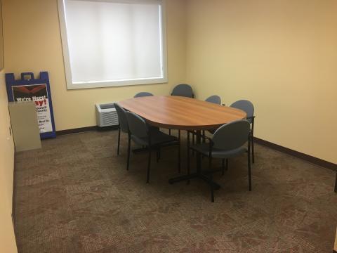 Small meeting room with single table and multiple chairs