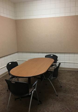 Small room with a rectangular table with four chairs placed around the table