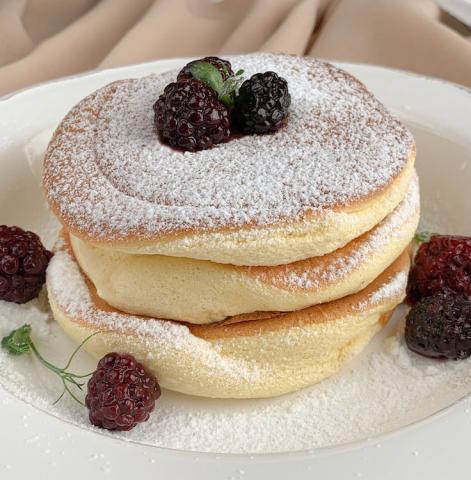 Fluffy Soufflé Pancake stack with berries and powdered sugar.