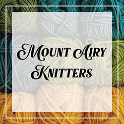 Mount Airy Knitters in a frame of colorful rolls of yarn