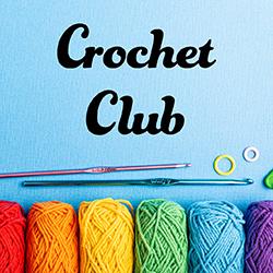 crochet hooks and multi-color yarn on a blue background