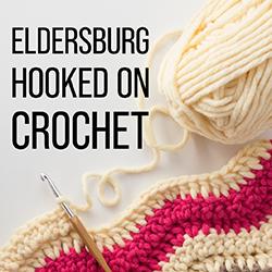 cream and red yarn with a crochet hook on a white background