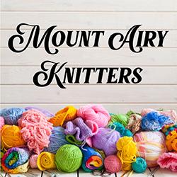 a pile of multicolored yarn in front of a light colored wood background