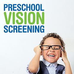 Little boy in a blue-striped shirt and blue vest laughing as he tries on a pair of glasses