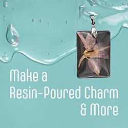 A small flower acrylic resin charm over a green background of poured resin