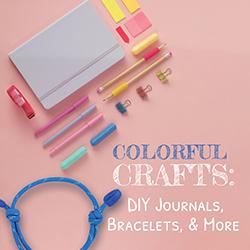 A blank journal with decorating supplies and a blue cord bracelet.