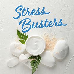 Homemade facial scrub in a white bowl surounded by fern fronds and minerals