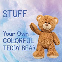 Teddy bear standing in front of blue and purple cotton stuffing.