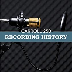 Close-up of a microphone with a gold band and audio baffle in front of a black waffle texture background.