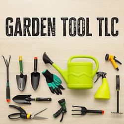 a variety of gardening tools on a light wooden background