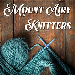 yarn and knitting needles on a wood background