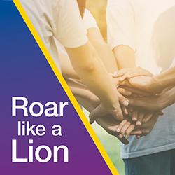 A group of people in a circle with camera focused on all hands in together.