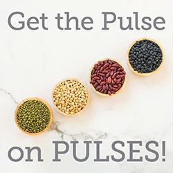 Bowls of different pulses arranged on a diagonal over a marble cutting board