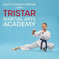 A girl in a karate pose in front of a blue background