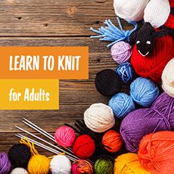 multi-color balls of yarn and knitting needleds on a wood background