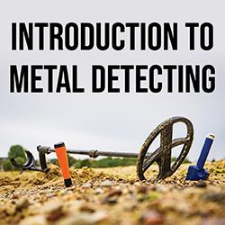 metal detector and small shovels on sand