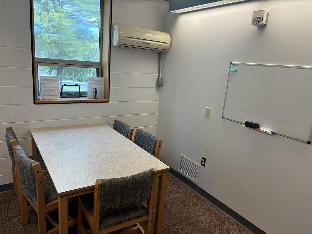 Table with 5 chairs and a whiteboard.