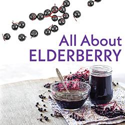 Fresh elderberries and elderberry syrup on a wooden tabletop