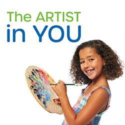 Little girl in a colorful sundress holding a painter's palette and brush and smiling at the camera.