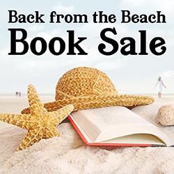 a starfish, hat, and book on a beach