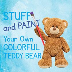 Teddy bear standing in front of a blue-painted paper.