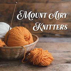 a basket of yarn with knitting needles