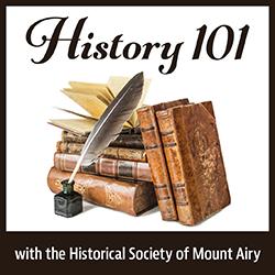 a stack of old books and a quill in an inkwell
