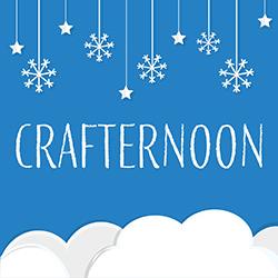 Cut white paper snowflakes, stars, and clouds over a blue paper background.