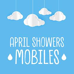 Cut paper clouds hanging from mobile strings over a blue background.